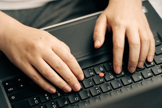 Person typing on a laptop, drafting a letter