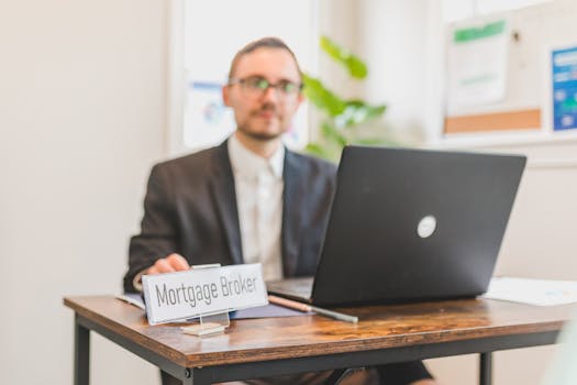 professional working on laptop with mortgage documents